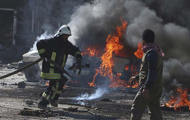 Bombeiro tenta apagar incndio de um carro que foi atingido por uma bomba na cidade de Aleppo, no norte da Sria, nesta quinta-feira