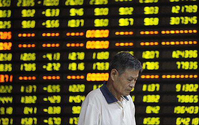 Investidor em frente a painel com informa��es da Bolsa, em corretora de Huaibei, na China