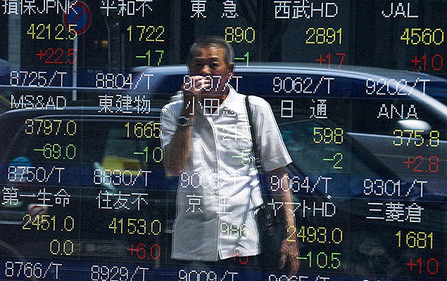 Homem acompanha painel com a cotao de aes da Bolsa de valores de Tquio