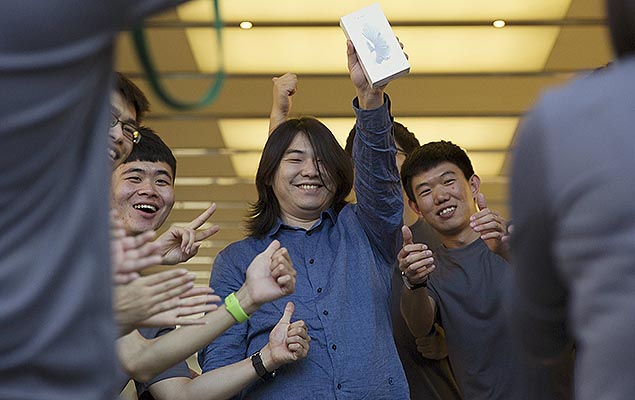 Funcionários de loja da Apple em Pequim, na China, comemoram a compra dos primeiros iPhone 6s, na manhã desta sexta-feira