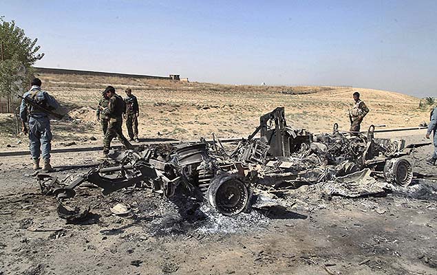 Soldados afegos observam carro destrudo prximo a cidade de Kunduz, no Afeganisto