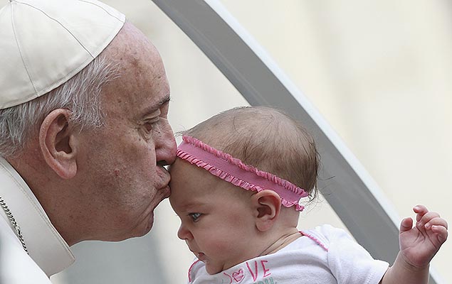 Papa Francisco beija um beb entregue por fiel na chegada a praa de So Pedro, no Vaticano