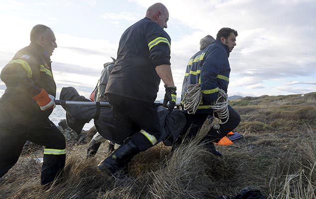 Na ilha de Lesbos, bombeiros gregos transportam corpo de migrante que morreu ao cruzar o mar Egeu