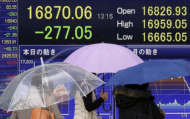 Pedestres passam por tela com informaes da Bolsa de Tquio, no Japo