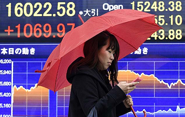 Mulher passa por painel com informaes da Bolsa em Tquio, no Japo