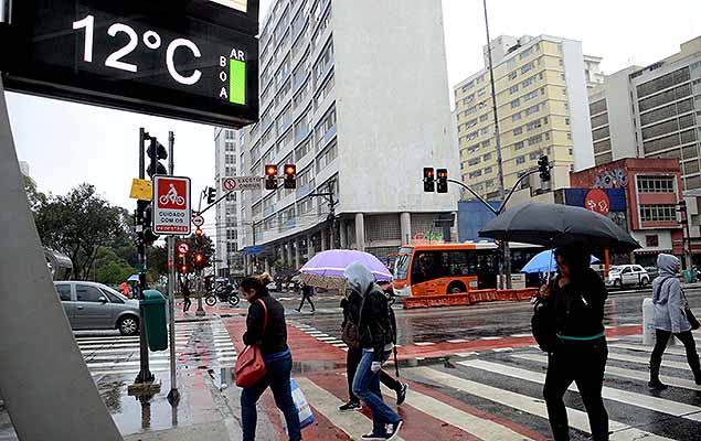 Pedestres se protegem da chuva na Avenida Paulista, em So Paulo (SP), nesta segunda-feira (22). A temperatura no momento  de 12C.
