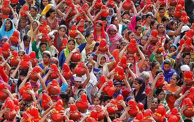 Fiis carregam potes de barro com gua durante procisso que marca o fim do festival Chaliha, na cidade de Ahmedabad (ndia)
