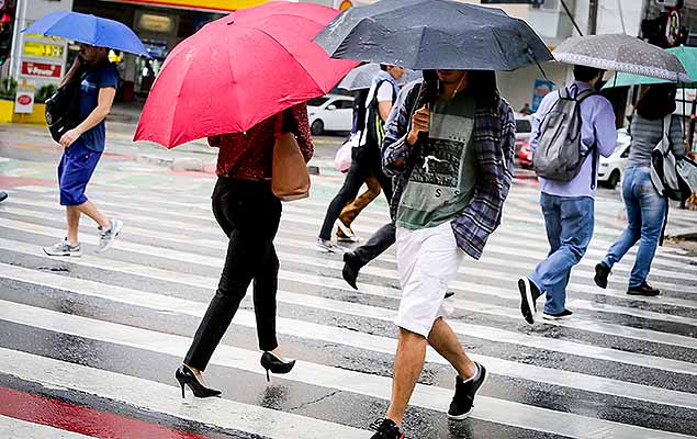 Pedestres se protegem da chuva; cidades do Rio de Janeiro entraram em ateno por conta dos temporais