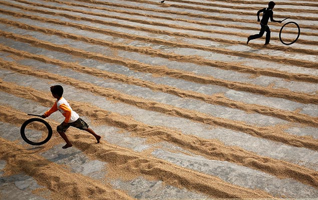 Crianas brincam com pneus em uma fbrica de processamento de arroz em Muktarpur, na periferia de Dhaka, em Bangladesh 