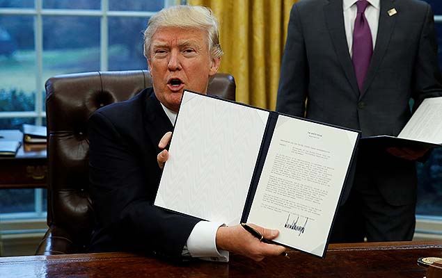 O presidente Donald Trump exibe no Salo Oval, em Washington, ordem executiva que retira os EUA do Tratado Transpacfico