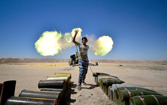Tropas paramilitares iraquianas disparam contra militantes do EI durante uma batalha no sul de Mossul 