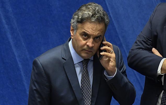 Senador Aécio Neves (PSDB) fala ao telefone durante sessão no Senado, em Brasília, na noite desta quarta