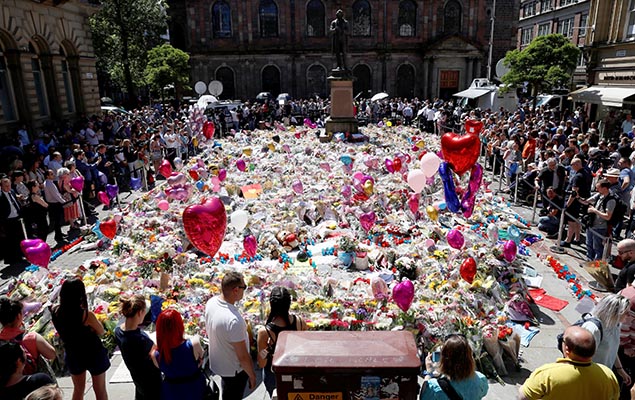 Moradores de Manchester, no Reino Unido, prestam homenagem às vítimas do atentado que deixou 22 mortos na cidade, nesta sexta