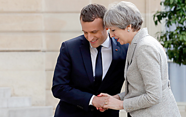 O presidente francs, Emmanuel Macron cumprimenta a primeira-ministra britnica, Theresa May, antes de um jantar de trabalho em Paris