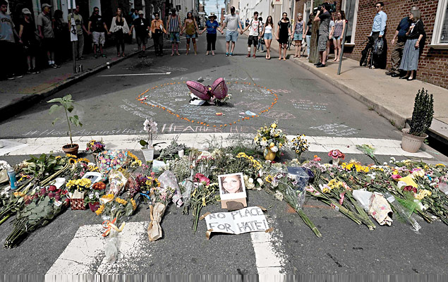As flores e uma foto da vítima do carro, Heather Heyer, encontram-se em um memorial improvisado em Charlottesville, Virgínia, 13 de agosto de 2017