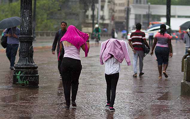 Pedestres se protegem da chuva no viaduto do Ch, no centro de SP, na manh desta segunda-feira (2)
