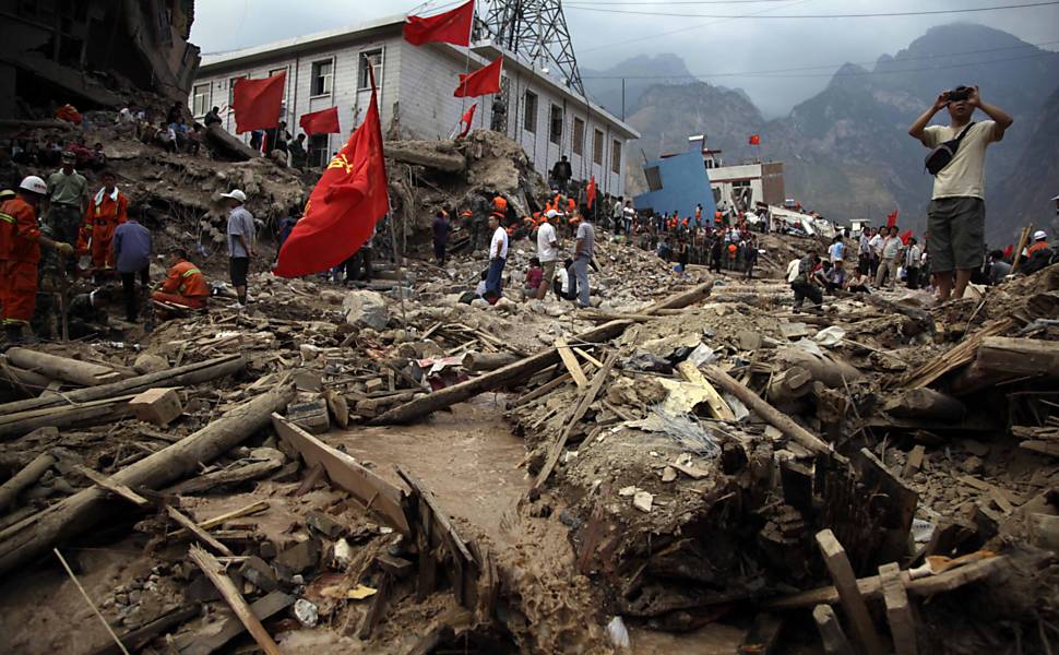 Homem fotografa cidade devastada de Zhouqu na Província de Gansu, na China. Ainda há 1.100 desaparecidos após os deslizamentos de terra