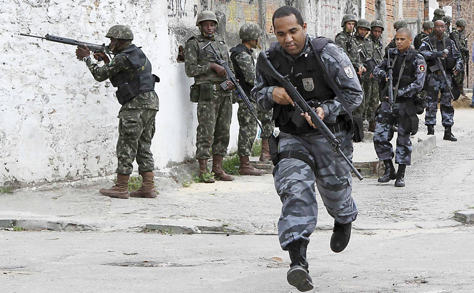 Policial corre durante operação na favela Nova Brasília Leia Mais