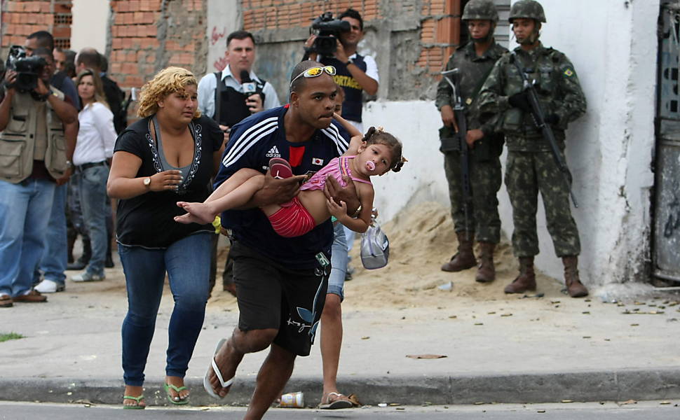 Moradores correm durante troca de tiros entre soldados e traficantes Leia Mais