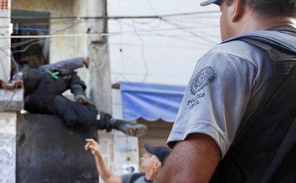 Policial pula portão de casa do Complexo do alemão durante operação militar Leia mais