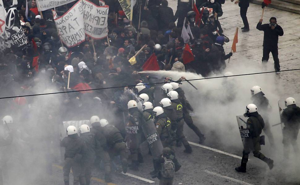 Policiais enfrentam manifestantes em frente ao Parlamento grego, no centro de Atenas Leia Mais