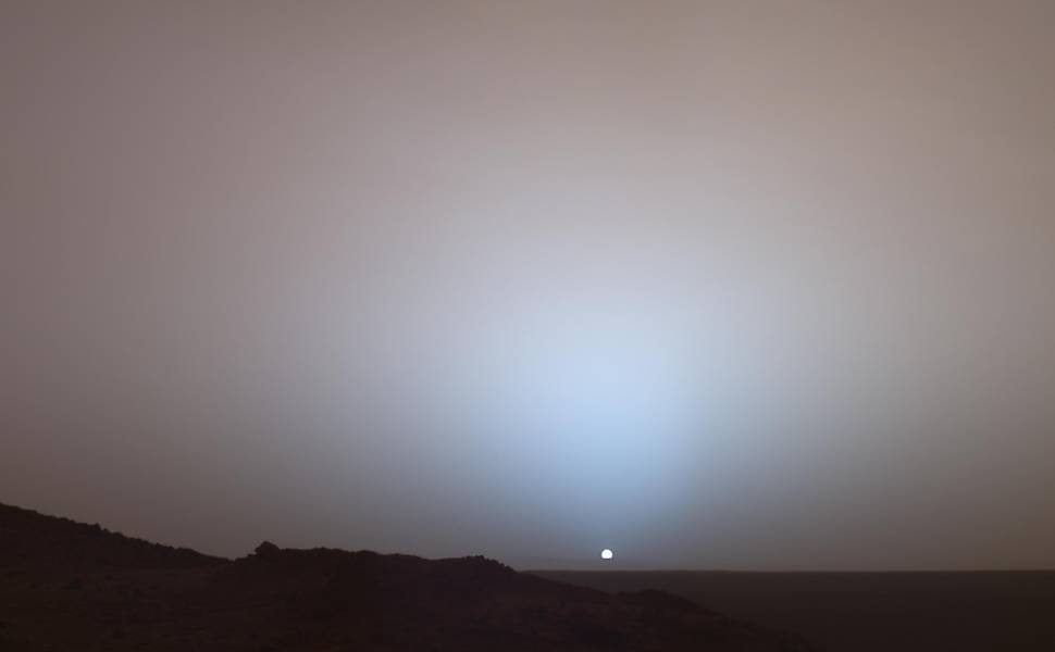 Pôr-do-sol em Marte fotografado pela sonda Spirit; a luminosidade acima do Sol pode ser vista até duas horas após o anoitecer Leia Mais