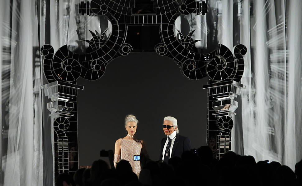 O estilista alemão Karl Lagerfeld (dir.) e modelo aplaudem no encerramento do desfile da Chanel