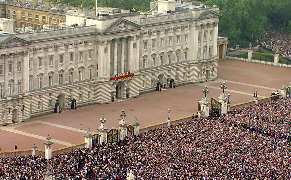 Pessoas se juntam em frente ao palácio de Buckinghan para ver o príncipe William e Kate Middleton Leia mais