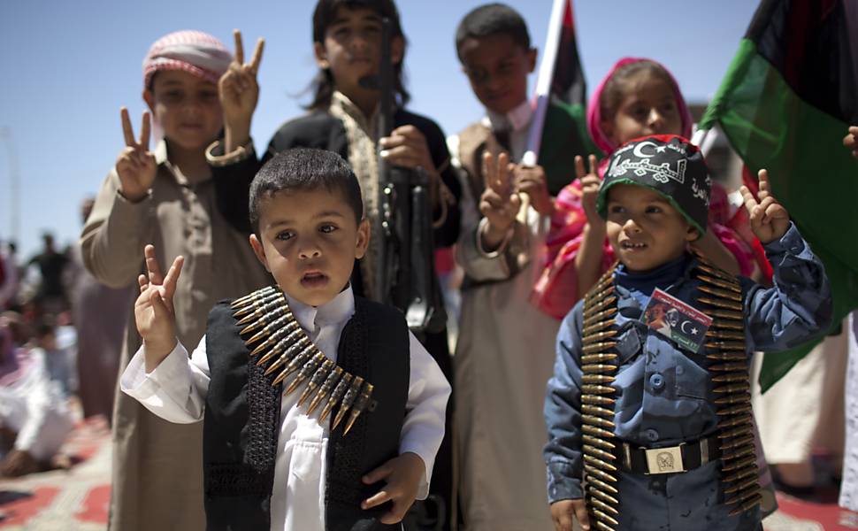 Crianças fazem sinal da paz durante ocupação dos rebeldes na cidade de Ajdabiya, na Líbia