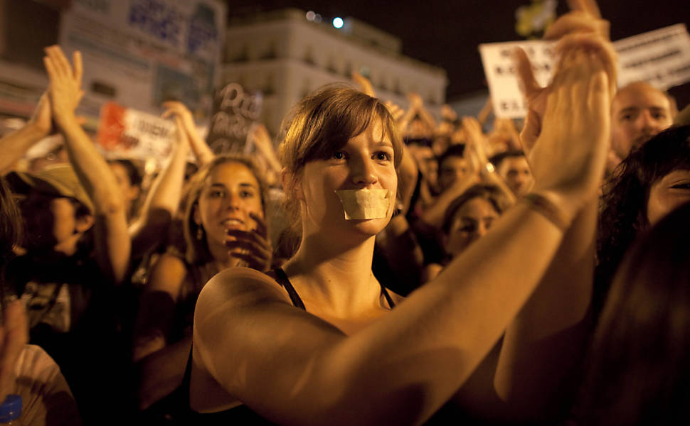 Mulher cobre a boca com fita adesiva durante protesto contra o governo realizado em Madri, na Espanha