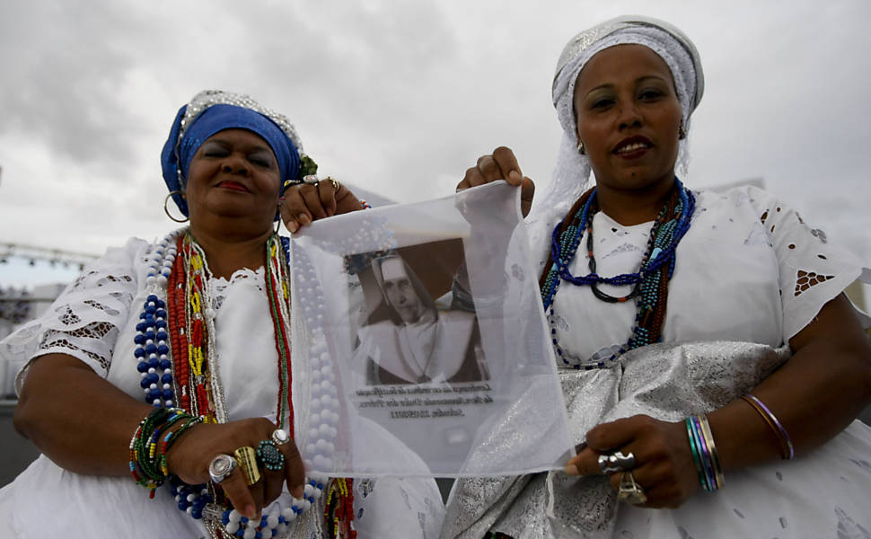 Baianas com seus trajes tradicionais segurando lenço com a imagem de Irmã Dulce durante a missa de sua beatificação, no Parque de Exposições de Salvador, na Bahia