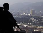 Com Maracanã ao fundo, policial é fotografado no morro da Mangueira, ocupado neste domingo em operação militar conjunta no Rio de Janeiro; motivação é a Copa do Mundo de 2014 Leia mais
