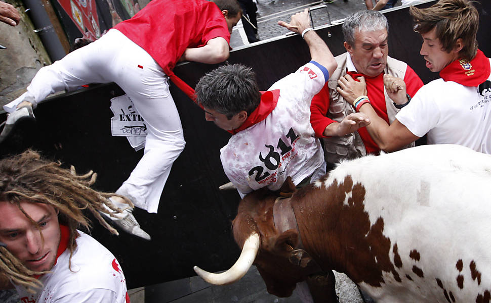 Pessoas tentam escapar de touro enfurecido na tradicional festa de São Firmino, em Pamplona, na Espanha 