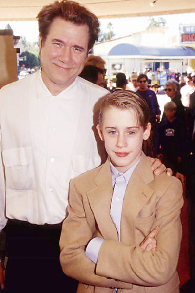 Ao lado de John Larroquette, Culkin posa durante pré-estreia de "Riquinho" em 1994