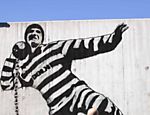 Homem caminha em frente a muro com grafitti dentro da prisão de Halden, no sudeste da Noruega Leia mais