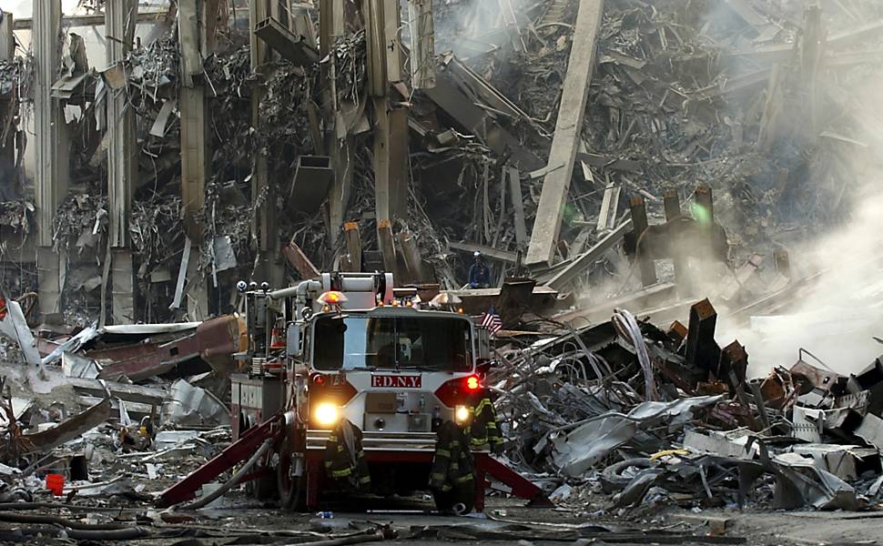 Um caminhão de bombeiros entre escombros resultantes da queda do WTC