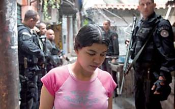 Moradora  observada por policiais do Bope em beco na favela da Rocinha, no Rio