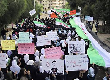 Manifestantes pr-democracia fazem ato em Homs, carregando cartazes em que se l "liberdade para os estudantes presos nos crceres de Assad"