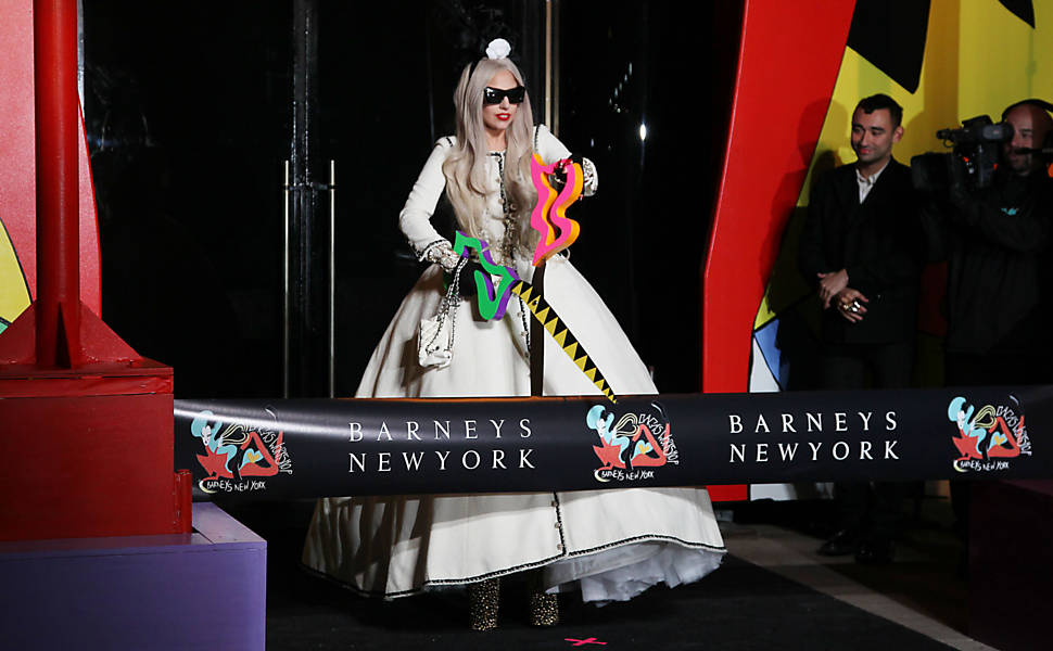 Lady Gaga corta a fita de inauguração da loja, chamada Gaga's Workshop, "uma experiência que presenta a reinterpretação de Gaga para o Natal