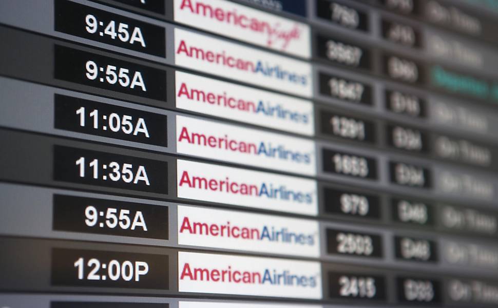 Painel no aeroporto de Miami (EUA) mostra status dos voos programados pela American Airlines, que pediu concordata Leia Mais
