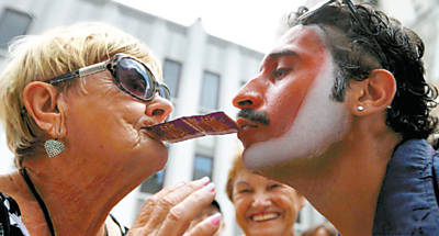 Mulher recebe camisinha de membro do grupo de teatro Filhos da Dita, no centro de So Paulo, em ao contra a Aids