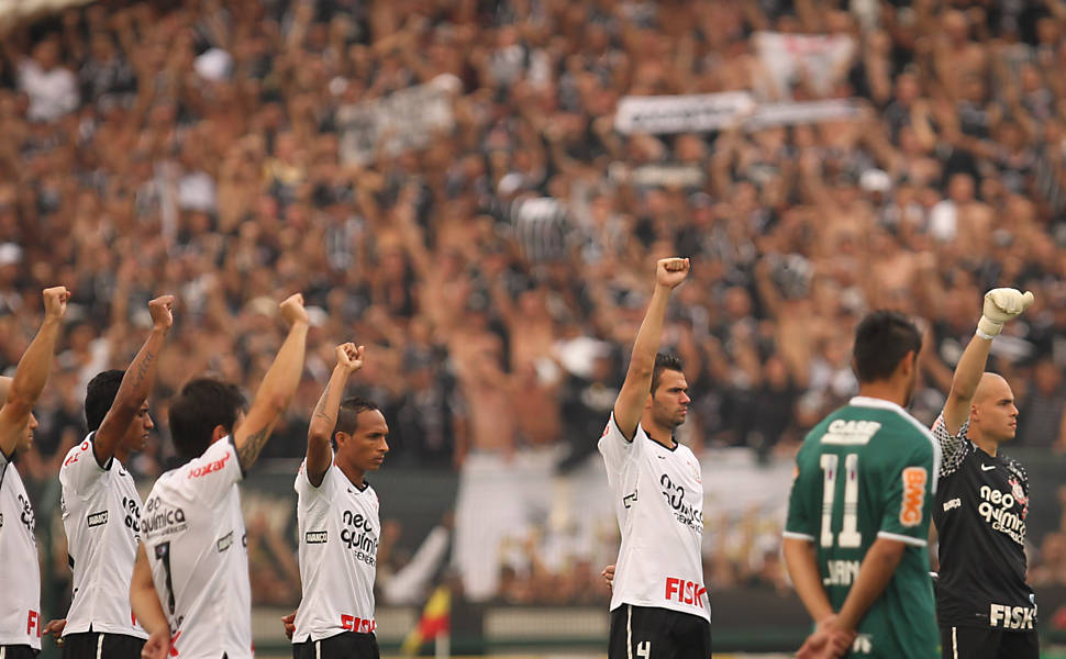 Jogadores do Corinthians homenageiam o ex-jogador Sócrates, fazendo seu gesto característico de quando comemorava gols;