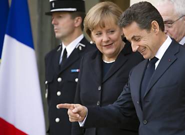Angela Merkel e Nicolas Sarkozy deixam o palcio presidencial francs, em Paris, aps reunio para discutir o pacote
