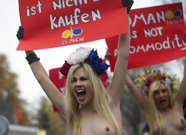 Seminuas, ativistas do Femen seguram faixa com os dizeres '"mulher no  commodity'"