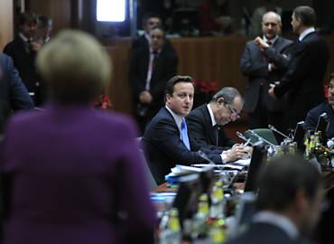 O primeiro-ministro britnico, David Cameron, olha para a chanceler alem, Angela Merkel, durante cpula europeia