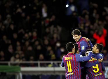 Messi pula sobre companheiros para celebrar o terceiro gol do Barcelona