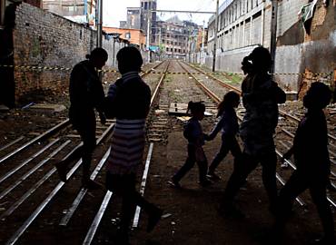 Moradores da favela passam pela linha do trem
