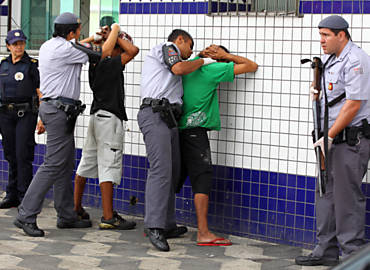 Policiais militares revistam suspeitos durante operação nas ruas da cracolândia, no centro