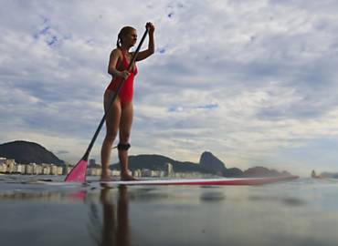 Com prancha maior e mais grossa, carioca pratica o surfe com remo na altura do 6, na praia de Copacabana, zona sul do Rio; modalidade comeou a ser praticada no Havai