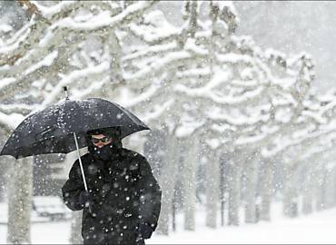 Homem caminha em parque totalmente coberto de neve em Burgos, no norte da Espanha